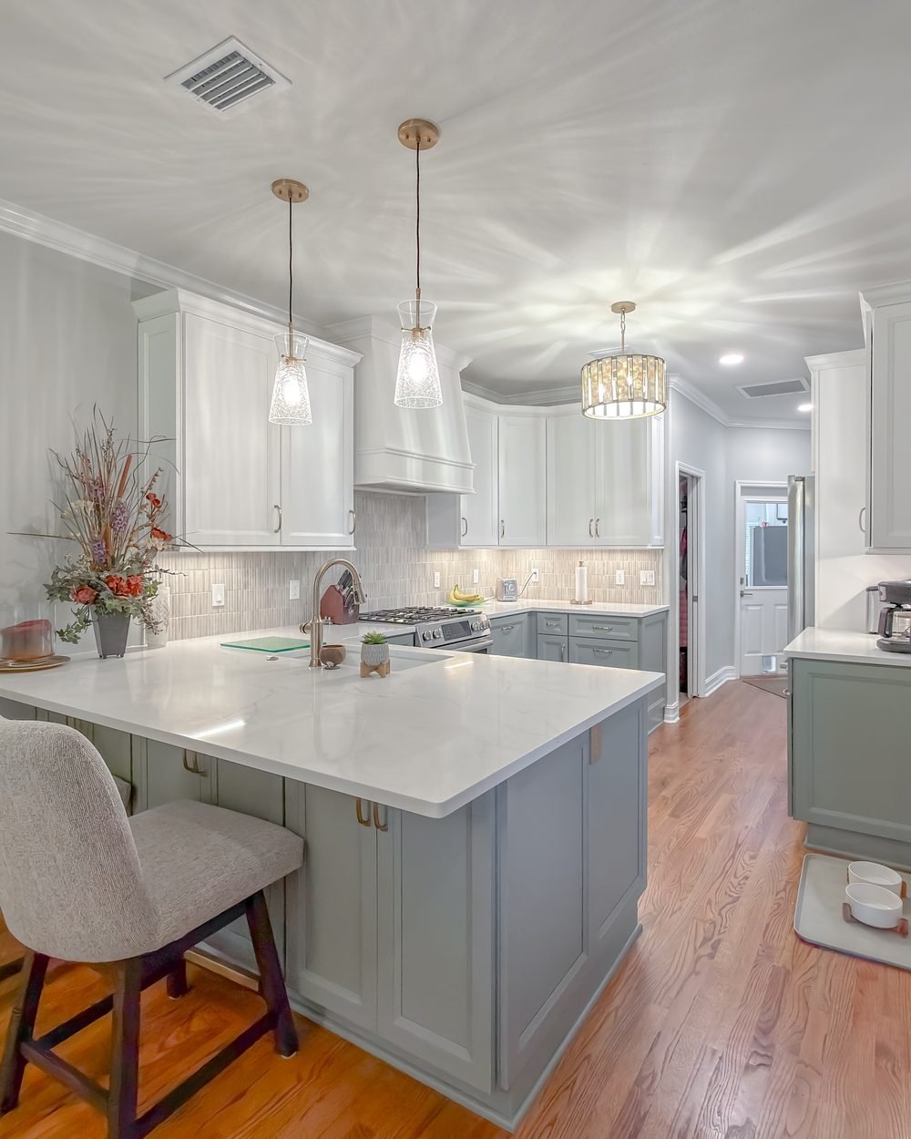 Renovated kitchen with a sage island, quartz counters and brass fittings. Tallahassee, FL