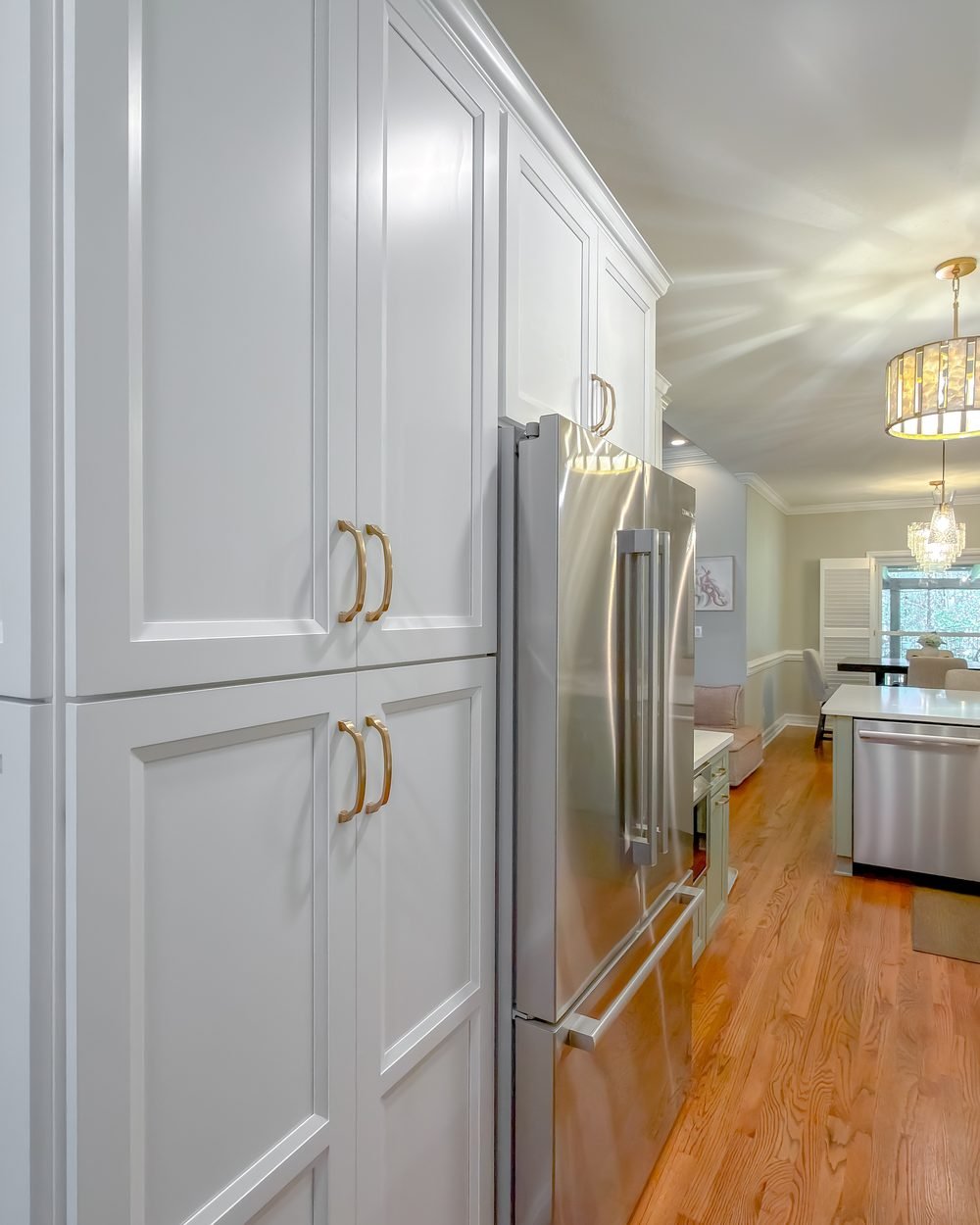 Renovated kitchen with a large island, gold chandelier and stainless range. Whole home renovation in Tallahassee, FL