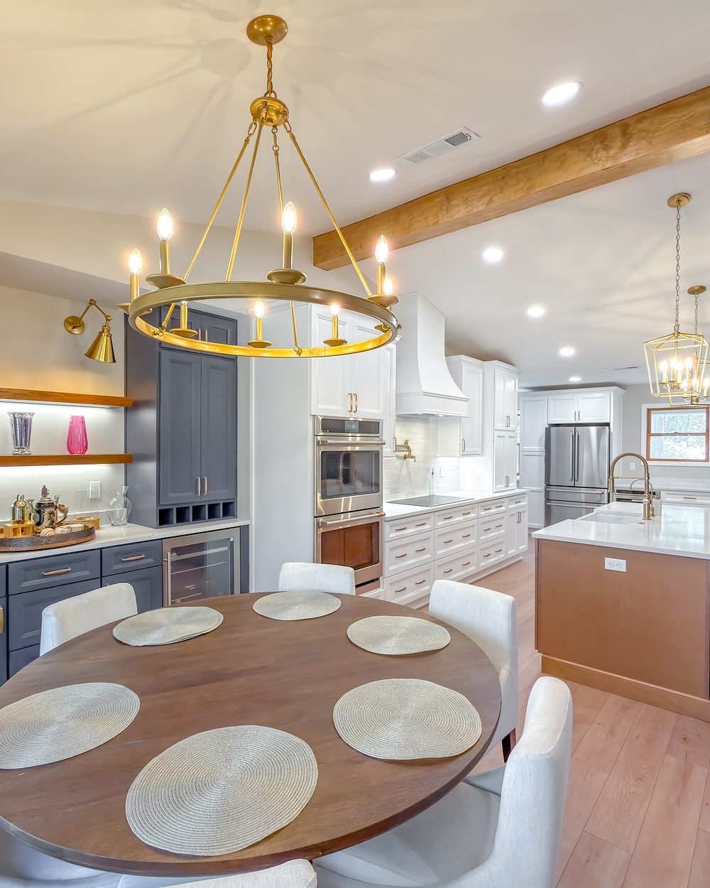 Open kitchen and dining room with navy cabinetry and a brass chandelier in a Tallahassee home