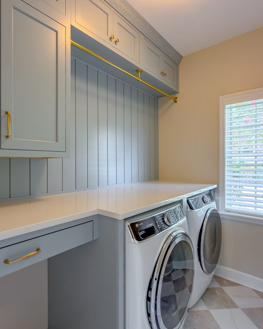 Laundry room with pale blue cabinetry, a folding counter and shaker panelling. Tallahassee, FL