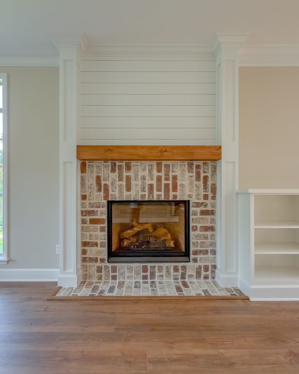 Living room with a brick fireplace flanked by custom built-in cabinetry in a Tallahassee home