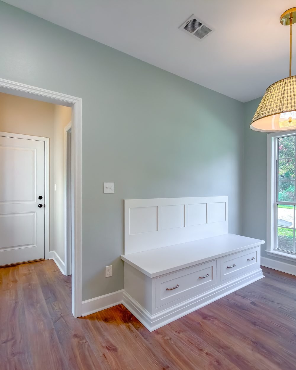 Built-in window seat with storage drawers beneath a bank of windows in a renovated living space. Tallahassee, FL