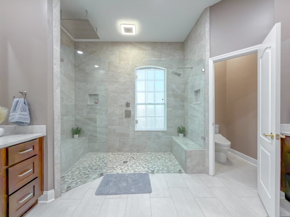 Walk-in shower with a built-in bench and an arched window. Tallahassee, Florida.