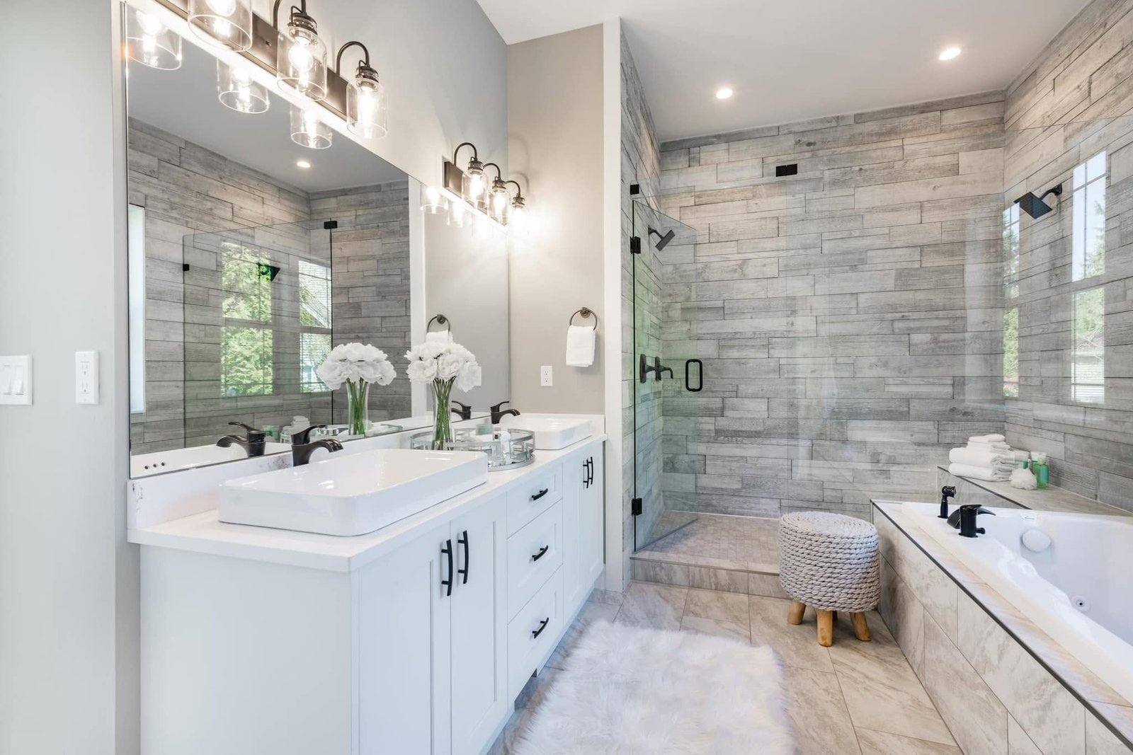Bathroom with a white double vanity, soaking tub and glass shower in wood-look tile. Tallahassee, Florida.