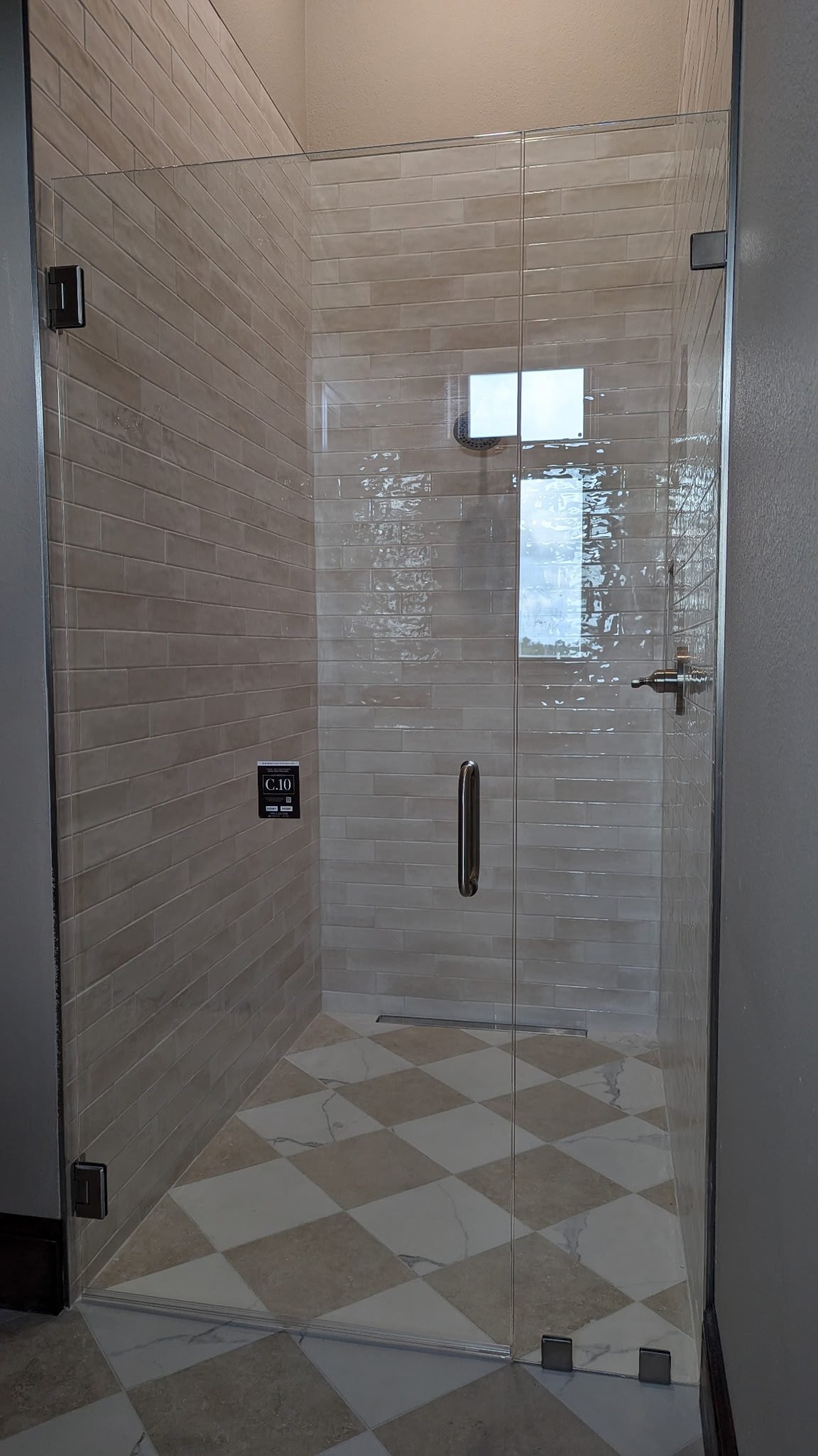 Glass shower enclosure above a harlequin tile floor. Tallahassee, Florida.