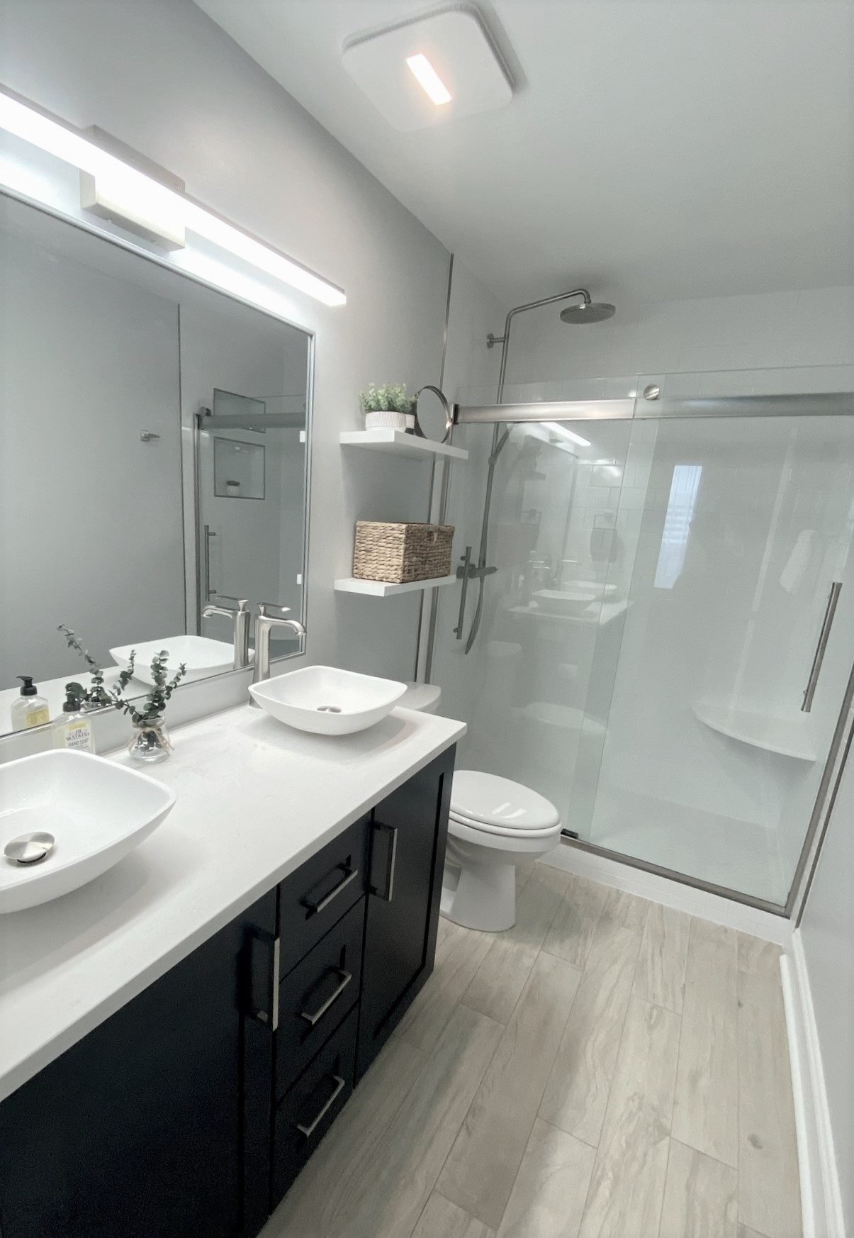 A double vanity with vessel basins and a frameless glass shower in a renovated bathroom, Tallahassee, FL