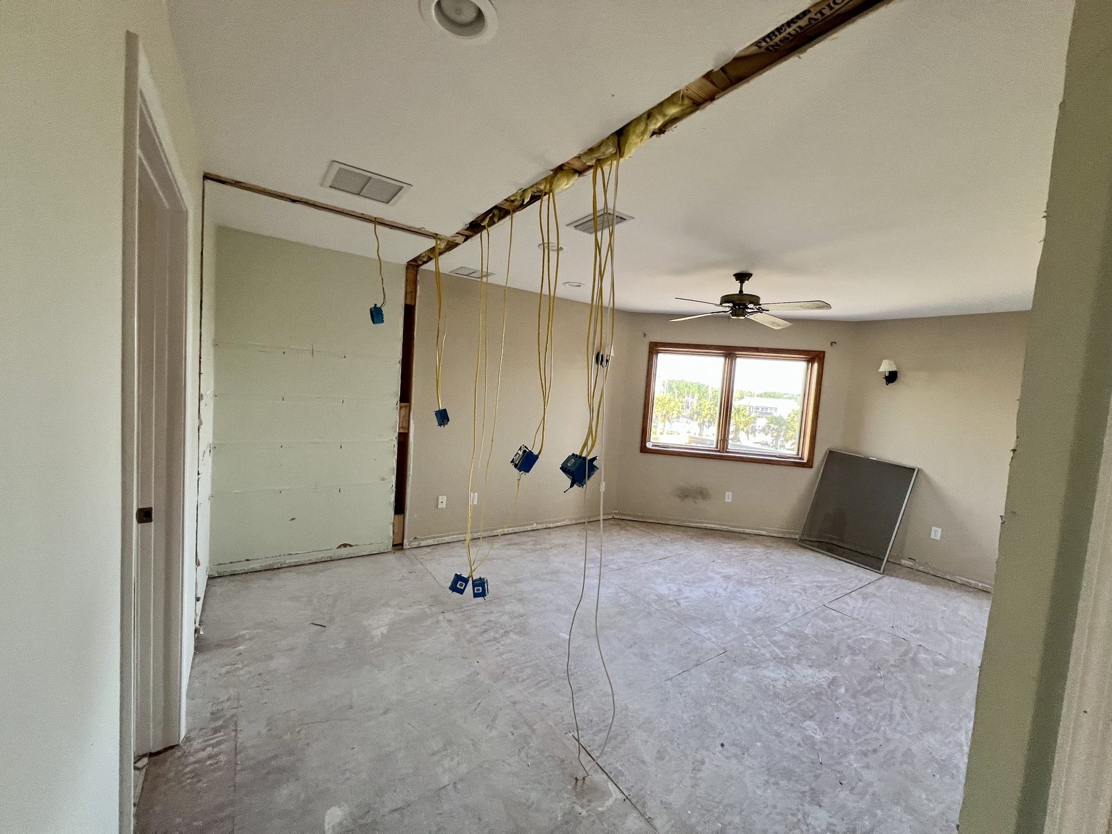 An engineered beam installed overhead after a load-bearing wall was removed, with electrical rough-in in progress, Tallahassee, FL