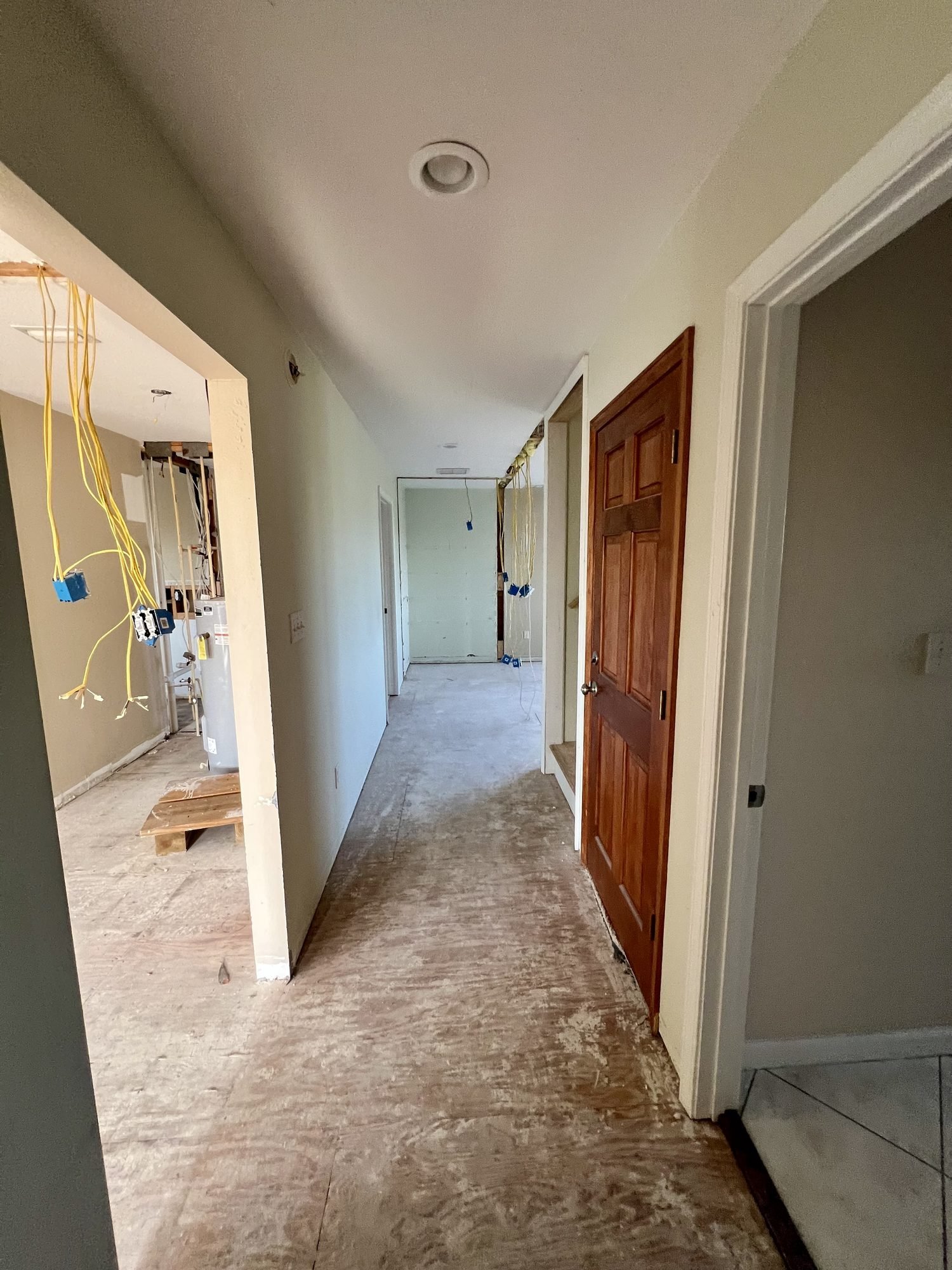 A hallway stripped to the subfloor with electrical wiring pulled ready for new flooring, Tallahassee, FL