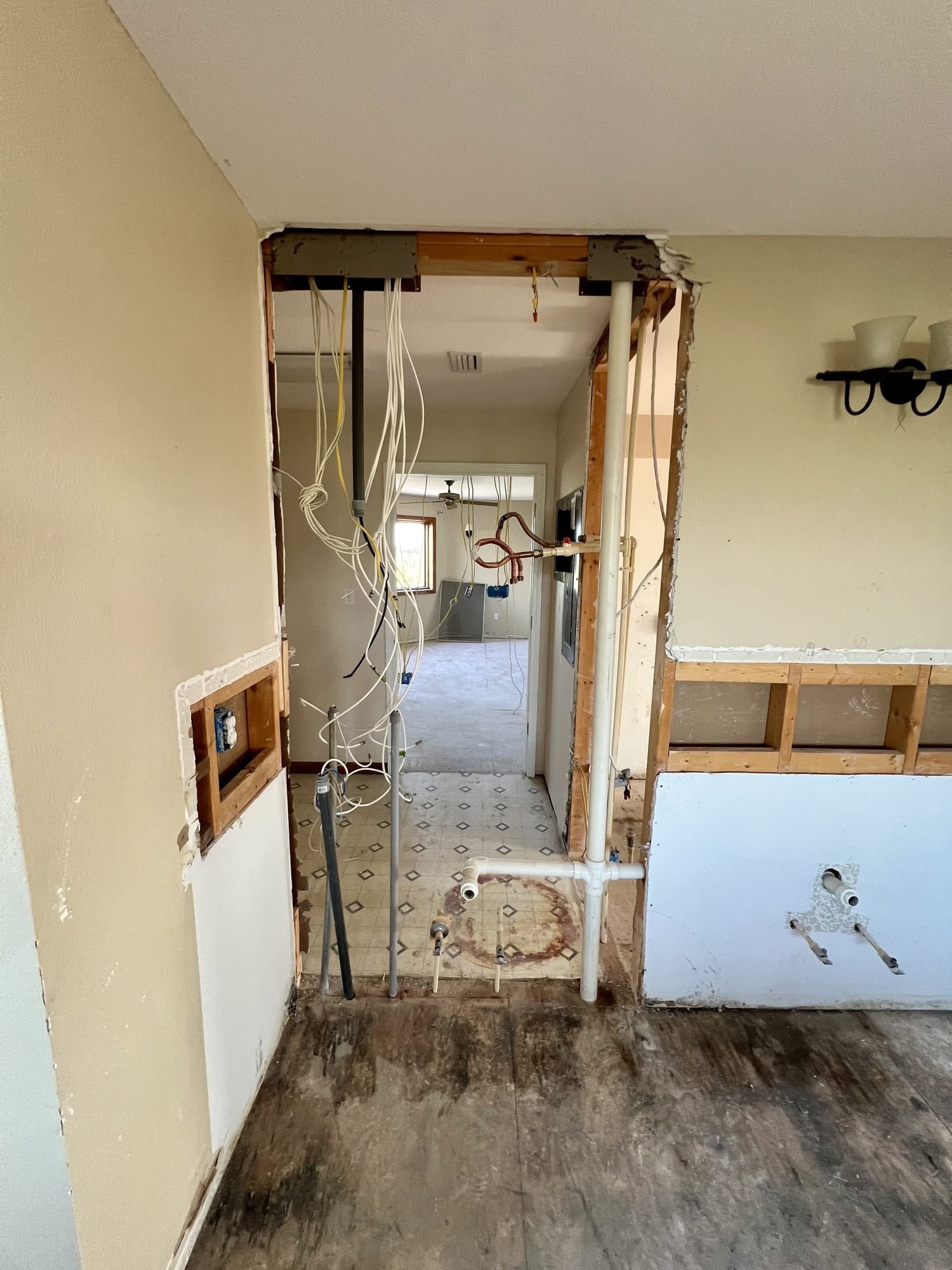 A new opening cut through an interior wall with the structural header in place and wiring rerouted, Tallahassee, FL