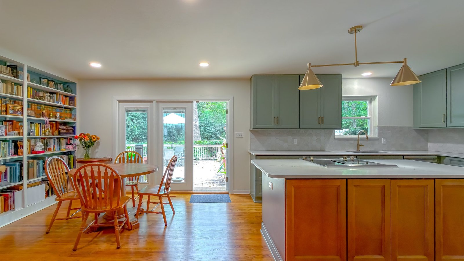 Renovated dining area opening to a kitchen, with French doors onto a wooded Tallahassee garden