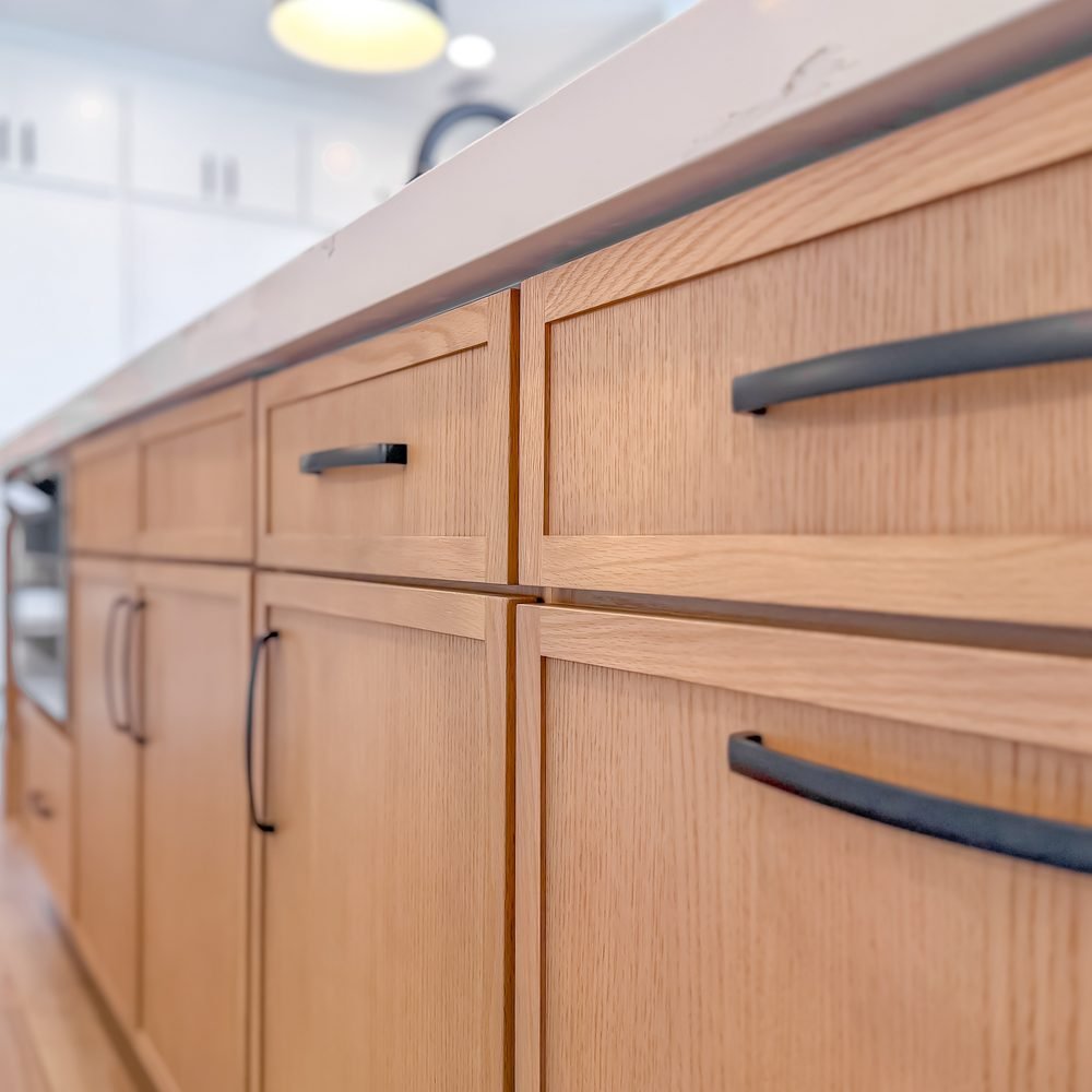 Detail of natural white oak cabinet fronts with matte black bar pulls. Residential renovation company Tallahassee, FL.