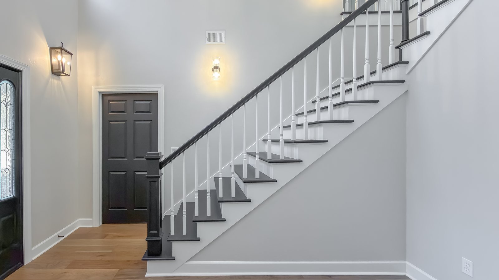 Entry hall with herringbone flooring and a staircase beyond. Tallahassee, FL