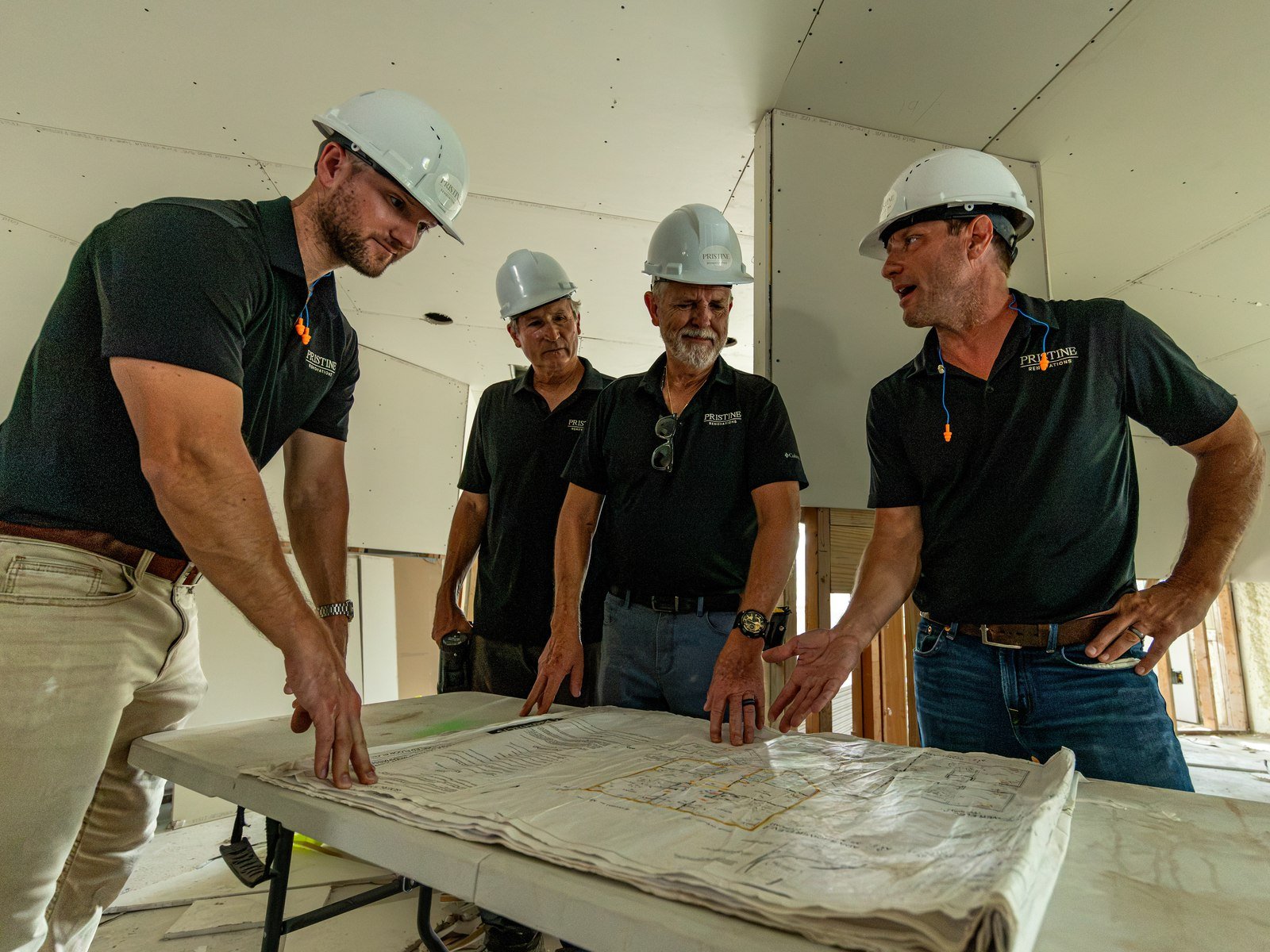 Pristine crew reviewing project drawings together at a worksite