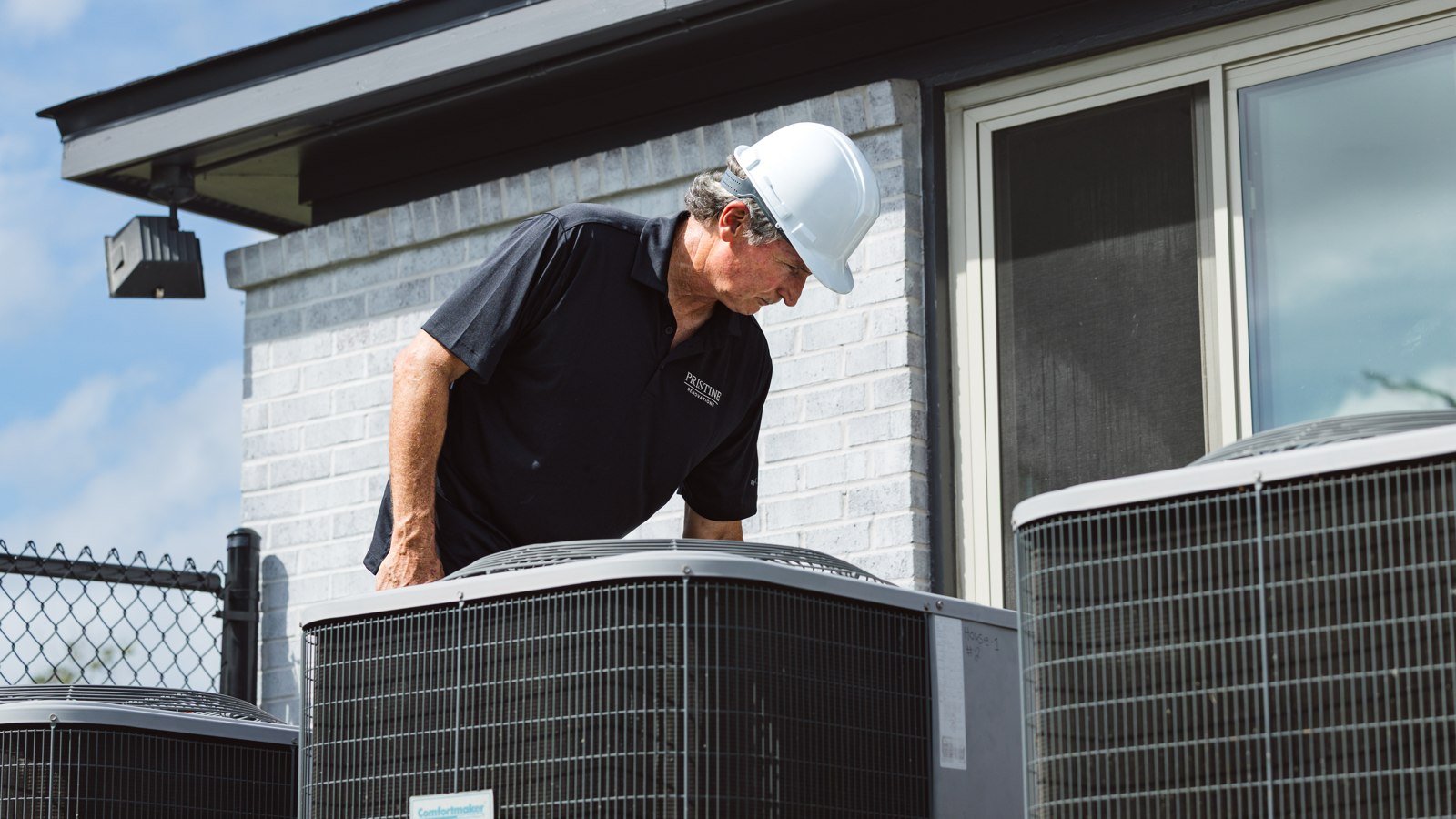 Pristine crew member checking equipment outside a home