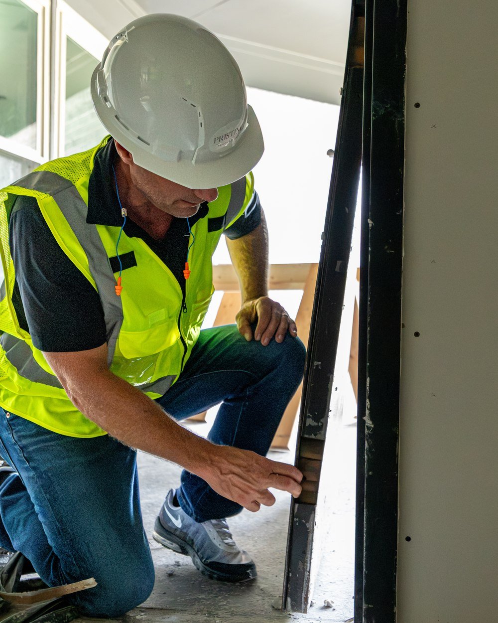 Pristine crew member measuring a wall opening during renovation