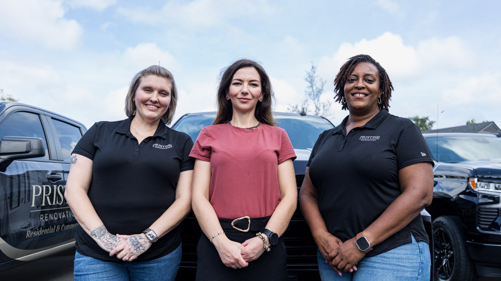 Three Pristine Renovations team members beside company trucks
