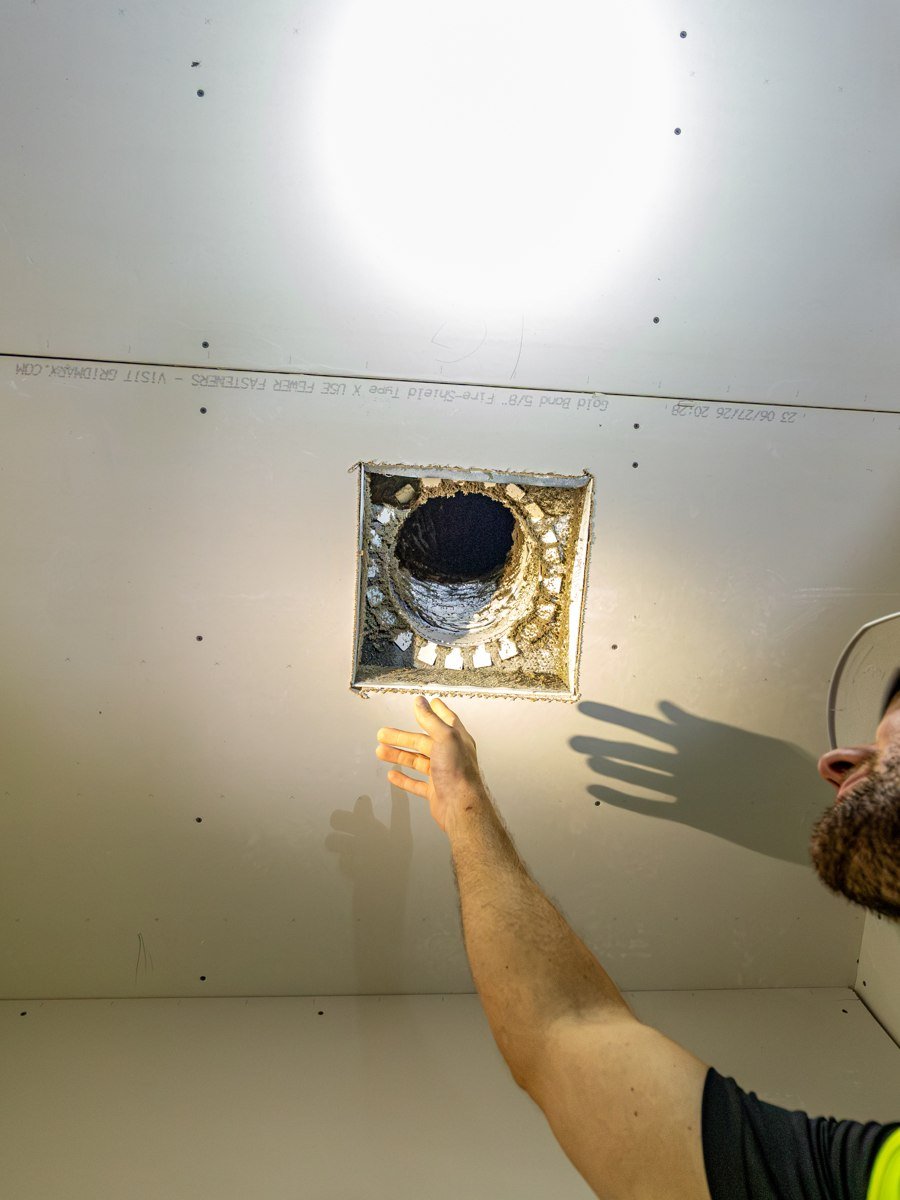 Pristine crew member inspecting a ceiling ventilation opening