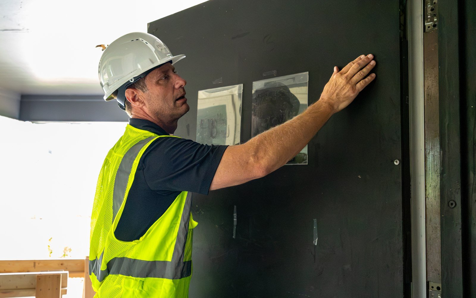 Pristine worker checking wall board during interior renovation